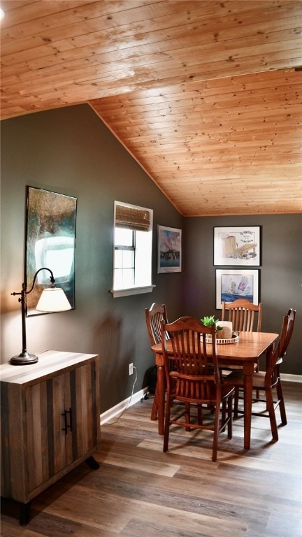 dining area with light wood-type flooring, wood ceiling, and vaulted ceiling