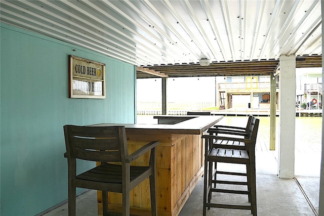 bar featuring concrete floors and a healthy amount of sunlight