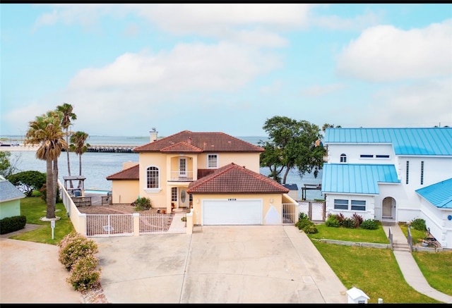 mediterranean / spanish home featuring a water view, a front lawn, and a balcony