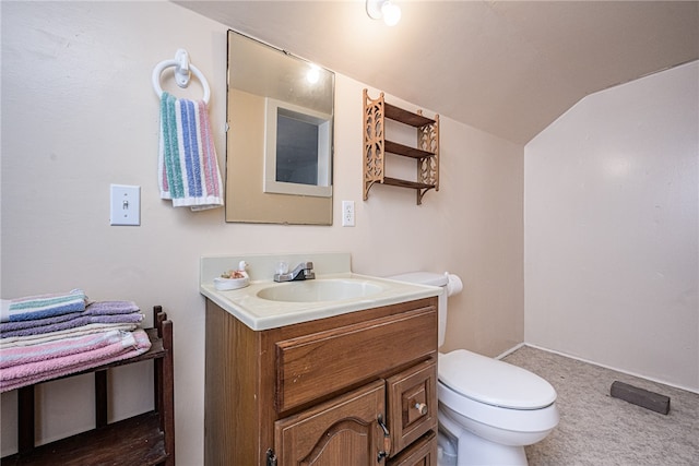 bathroom with vanity, toilet, and lofted ceiling