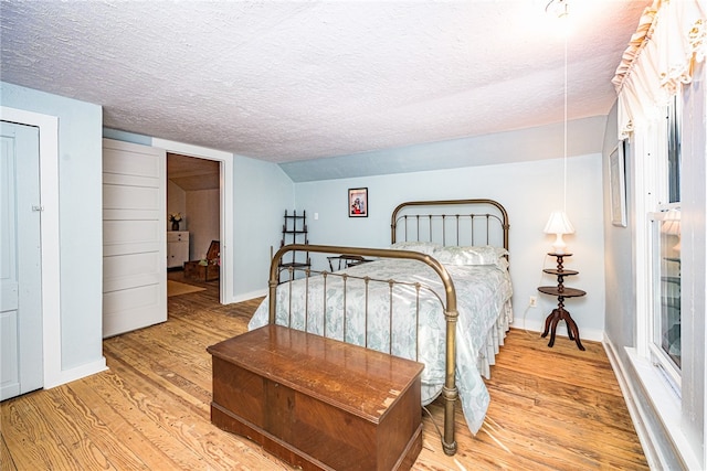 bedroom with a textured ceiling and light wood-type flooring