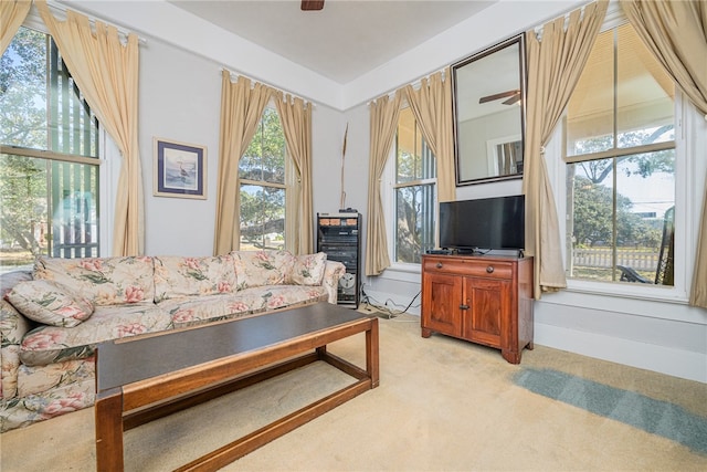 living room featuring light carpet, plenty of natural light, and ceiling fan