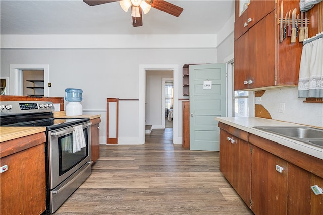 kitchen featuring stainless steel electric stove, ceiling fan, and light hardwood / wood-style floors