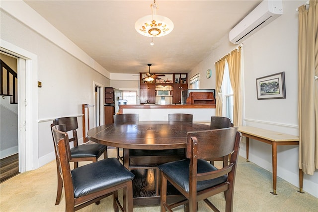 carpeted dining area featuring ceiling fan and a wall mounted AC