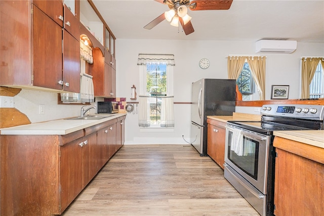 kitchen with sink, light wood-type flooring, stainless steel appliances, and a wall mounted AC