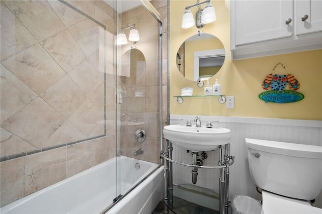 full bathroom with sink, toilet, and combined bath / shower with glass door