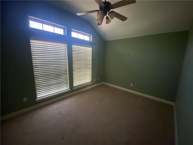 carpeted empty room featuring lofted ceiling and a ceiling fan