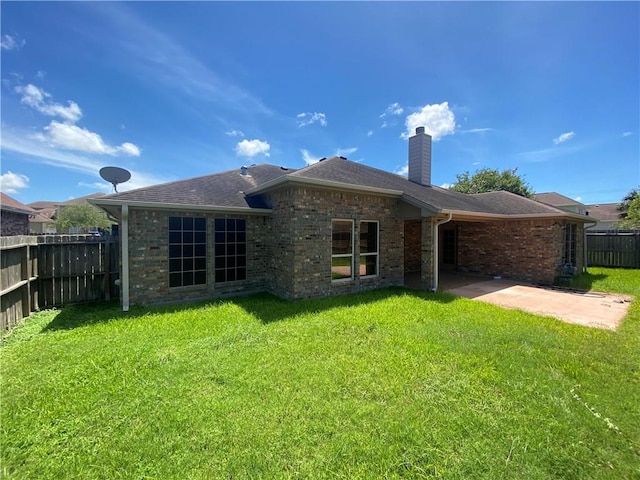 rear view of property with a chimney, a patio, brick siding, and a shingled roof