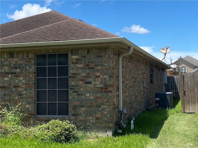 view of side of property featuring roof with shingles and a cooling unit