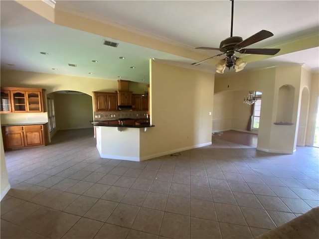 unfurnished living room featuring arched walkways, tile patterned floors, ceiling fan, ornamental molding, and recessed lighting