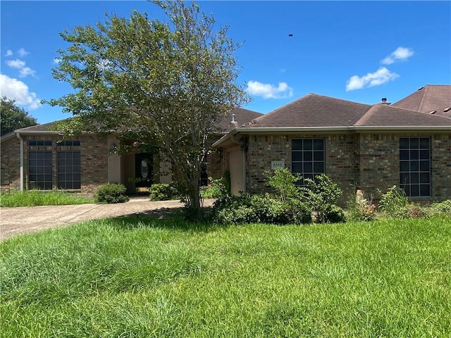 view of front facade with brick siding and a front yard