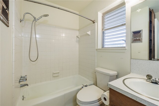 full bathroom featuring toilet, tiled shower / bath combo, vanity, and backsplash