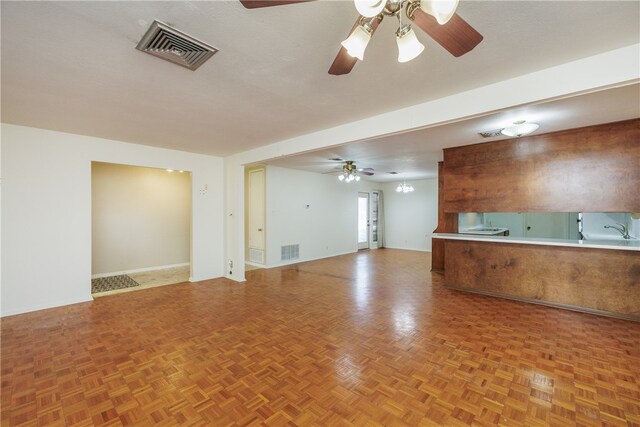 unfurnished living room with ceiling fan and parquet floors