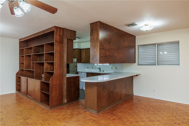 kitchen with sink, kitchen peninsula, ceiling fan, light parquet flooring, and white refrigerator