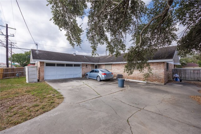 ranch-style house featuring a garage and a front lawn