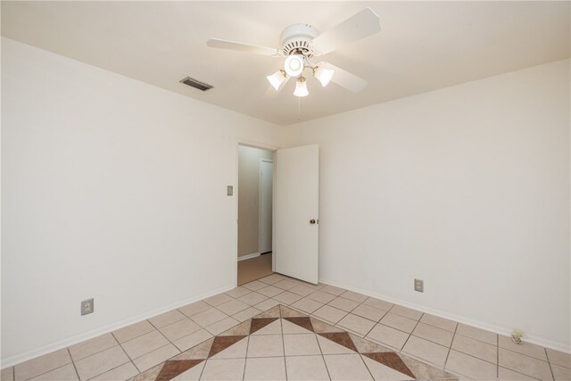 empty room with light tile patterned flooring and ceiling fan