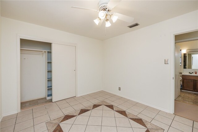 unfurnished bedroom with a closet, ceiling fan, and light tile patterned floors