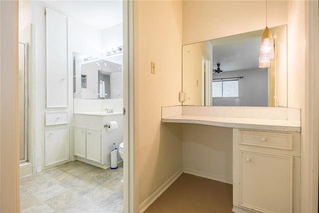 bathroom featuring ceiling fan, vanity, a shower with door, and toilet