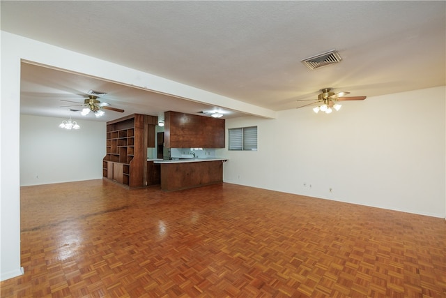 unfurnished living room with parquet flooring, ceiling fan, and a textured ceiling