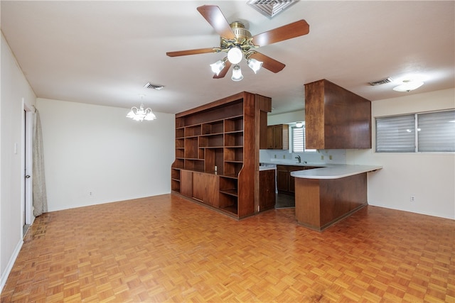 kitchen featuring light parquet floors, kitchen peninsula, and ceiling fan with notable chandelier