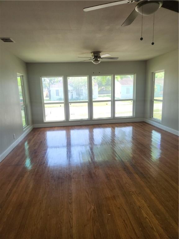 615 E Henderson St, Bishop, TX 78343 - unfurnished living room featuring baseboards, a ceiling fan, dark wood-style floors, and visible vents