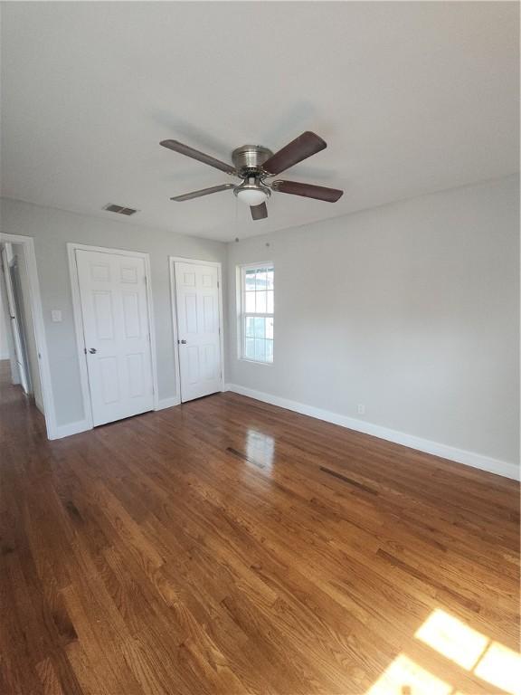 615 E Henderson St, Bishop, TX 78343 - unfurnished bedroom featuring baseboards, ceiling fan, wood finished floors, and visible vents