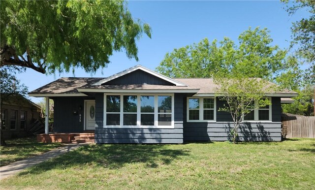 615 E Henderson St, Bishop, TX 78343 - view of front of property featuring fence, a shingled roof, and a front lawn