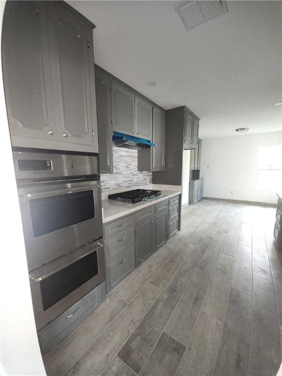615 E Henderson St, Bishop, TX 78343 - kitchen with stainless steel appliances, gray cabinets, and light wood-style flooring