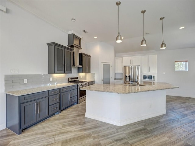 kitchen featuring appliances with stainless steel finishes, backsplash, light stone countertops, a large island, and recessed lighting