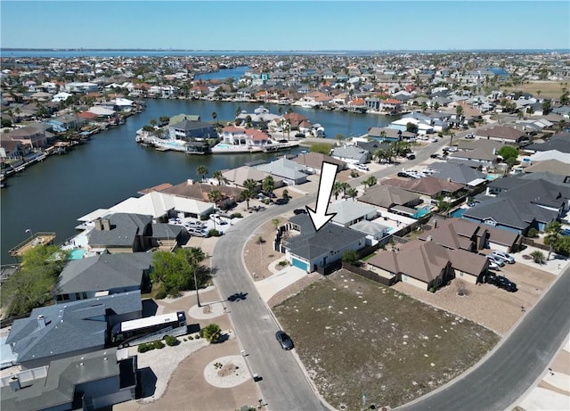 aerial view of property and surrounding area with nearby suburban area and a large body of water