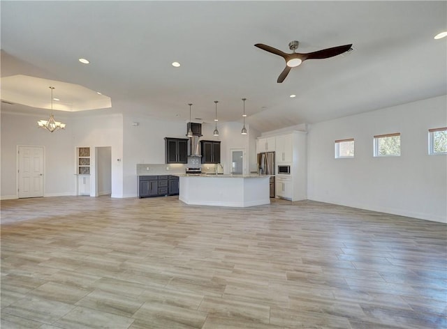 unfurnished living room featuring a chandelier, a ceiling fan, baseboards, recessed lighting, and lofted ceiling