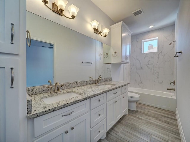 bathroom with toilet, double vanity, and shower / tub combination