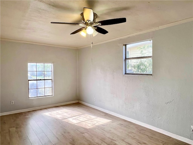 spare room with ornamental molding, light wood-type flooring, and ceiling fan