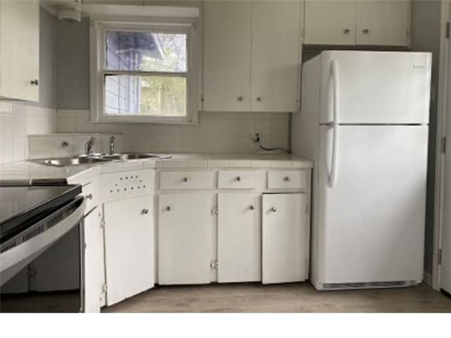 kitchen with black range with electric cooktop, backsplash, white refrigerator, sink, and white cabinets