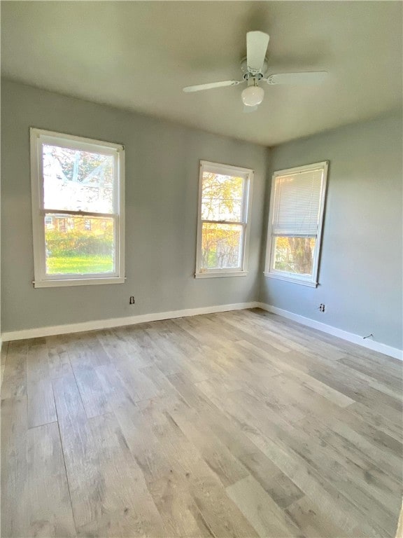 spare room featuring plenty of natural light, light hardwood / wood-style floors, and ceiling fan