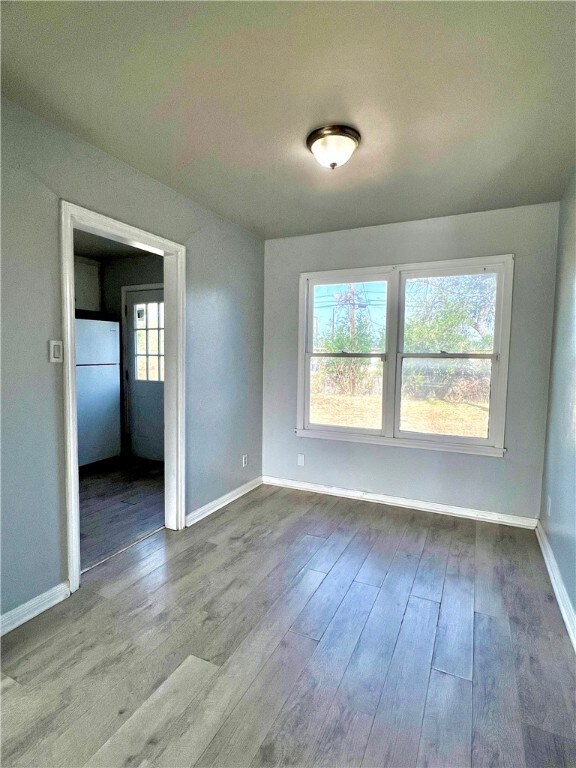 empty room with hardwood / wood-style flooring and plenty of natural light