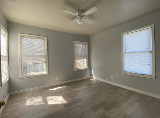 spare room with dark hardwood / wood-style flooring and ceiling fan