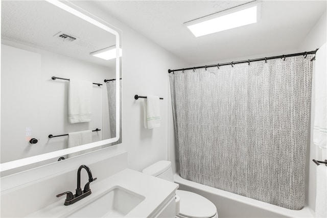 full bathroom featuring vanity, shower / bath combo with shower curtain, and toilet