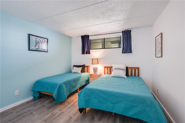 bedroom featuring a textured ceiling and hardwood / wood-style flooring