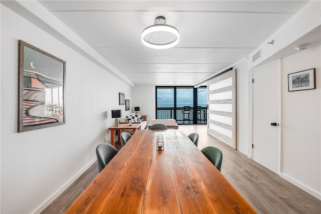 dining space featuring floor to ceiling windows and wood-type flooring