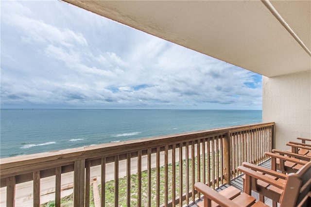 balcony with a water view and a view of the beach