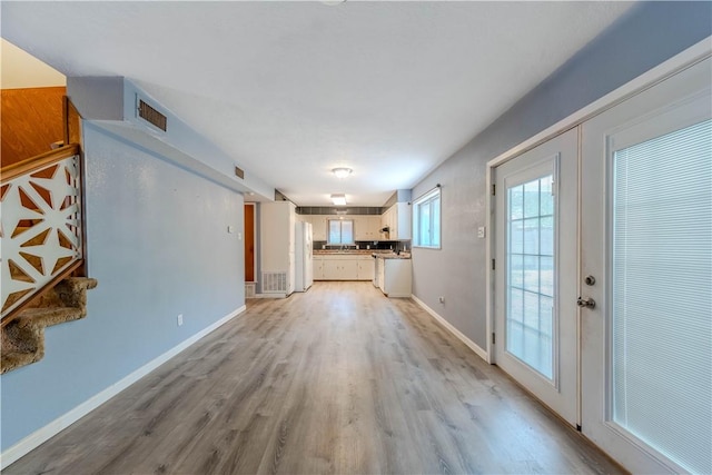 5813 Academy Dr, Corpus Christi, TX 78407 - unfurnished living room featuring light wood finished floors, french doors, and baseboards