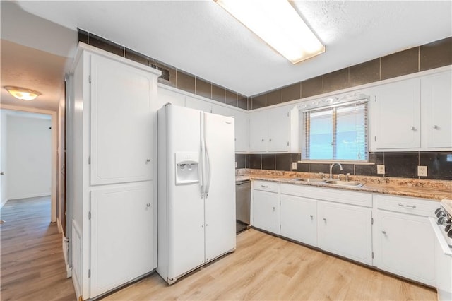 5813 Academy Dr, Corpus Christi, TX 78407 - kitchen featuring white fridge with ice dispenser, light wood finished floors, a sink, and white cabinetry