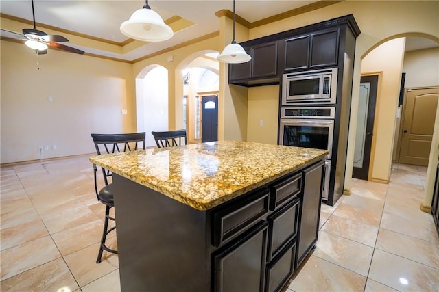 6725 Brooke Rd, Corpus Christi, TX 78414 - kitchen with appliances with stainless steel finishes, arched walkways, crown molding, a kitchen bar, and light tile patterned floors