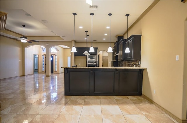 6725 Brooke Rd, Corpus Christi, TX 78414 - kitchen with arched walkways, stainless steel appliances, a peninsula, backsplash, and light stone counters