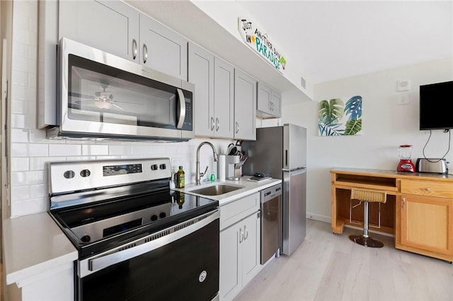 kitchen featuring white cabinets, appliances with stainless steel finishes, light countertops, and a sink