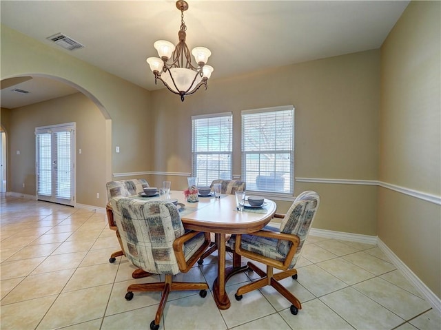 dining space with light tile patterned flooring and an inviting chandelier