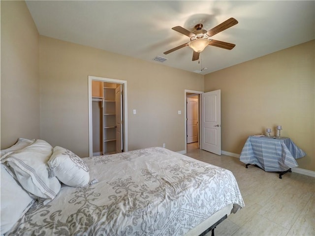 bedroom with a walk in closet, ceiling fan, and a closet