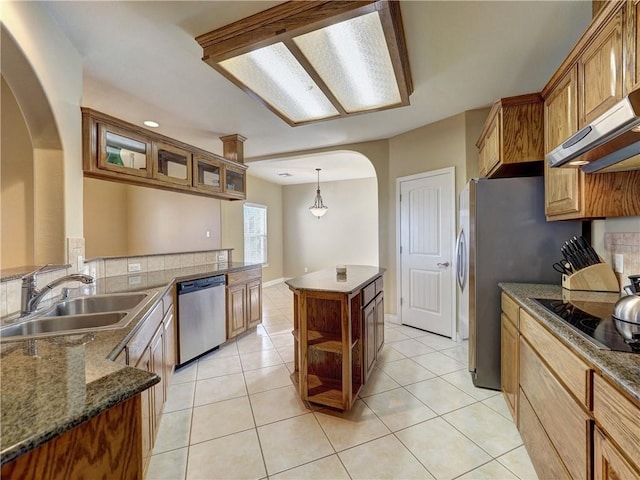 kitchen with light tile patterned flooring, appliances with stainless steel finishes, a kitchen island, and sink