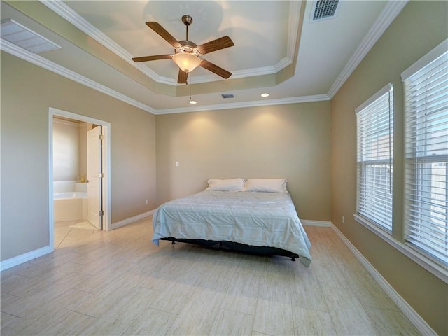 bedroom featuring connected bathroom, a tray ceiling, ceiling fan, and ornamental molding